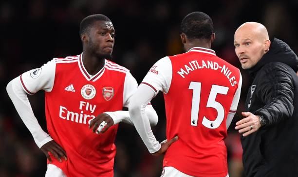 Arsenal's Swedish Interim head coach Freddie Ljungberg (R) speaks with Arsenal's French-born Ivorian midfielder Nicolas Pepe (L) and Arsenal's English midfielder Ainsley Maitland-Niles during the English Premier League football match between Arsenal and Manchester City at the Emirates Stadium in London on December 15, 2019. (Photo by Ben STANSALL / AFP)