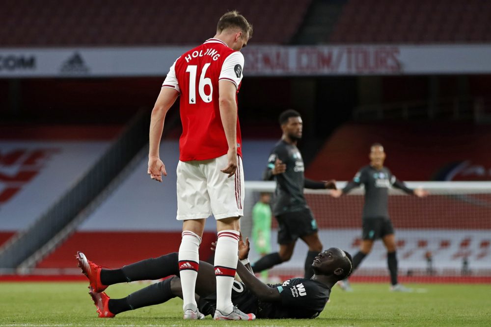 Arsenal's English defender Rob Holding (L) clashes with Liverpool's Senegalese striker Sadio Mane during the English Premier League football match between Arsenal and Liverpool at the Emirates Stadium in London on July 15, 2020. (Photo by PAUL CHILDS / POOL / AFP)
